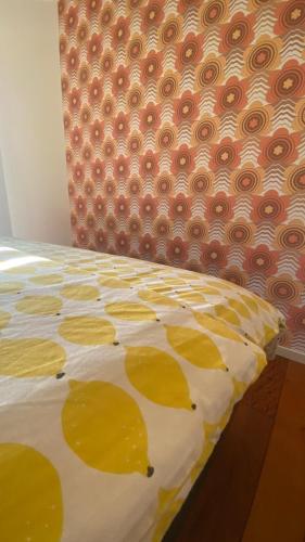 a bed with a yellow and white comforter at B&B NR6 in Herbaijum