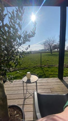 a table and chairs on a deck with a view of a field at B&B NR6 in Herbaijum