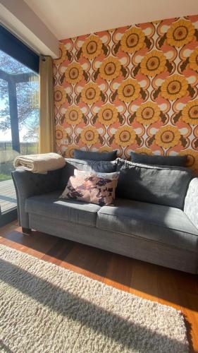 a couch sitting in a living room with a wall at B&B NR6 in Herbaijum