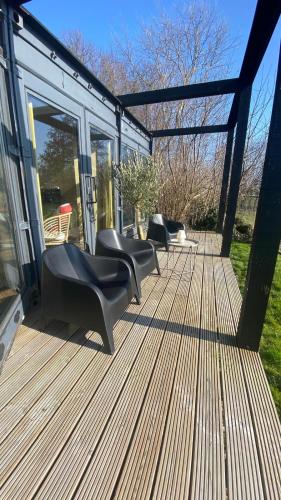 a deck with two chairs and chairs on it at B&B NR6 in Herbaijum