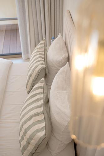 a white bed with pillows on top of it at Maison Raphaël studios - Plages, Ville et Gare à Pied in Saint-Raphaël