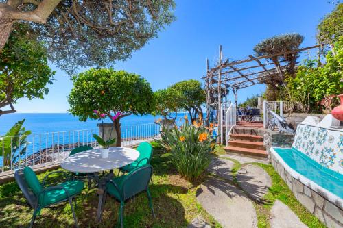 a patio with a table and chairs and the ocean at La Maliosa Positano in Positano