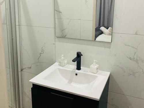 a bathroom with a white sink and a mirror at Shengelezi Guest House in Jozini