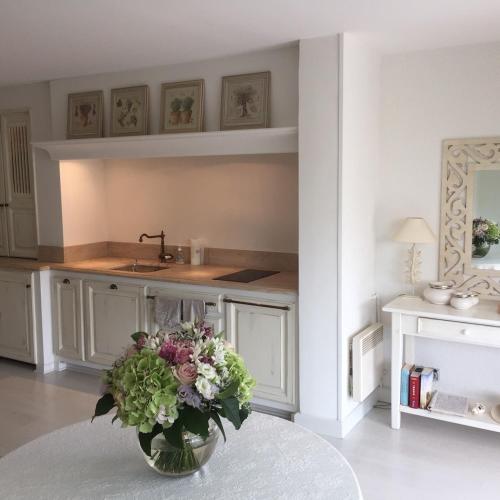 une cuisine avec un vase de fleurs sur une table dans l'établissement High Standing App , Sea front, à Gassin