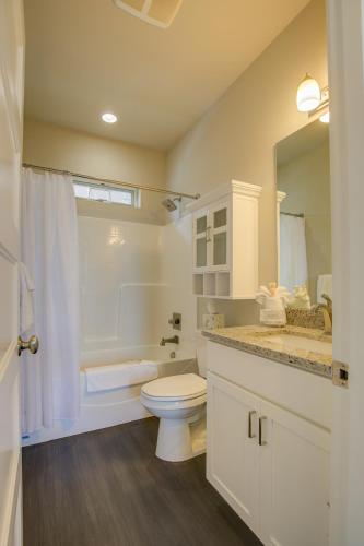 a white bathroom with a toilet and a sink at Starfish Cottage in Ocean Shores