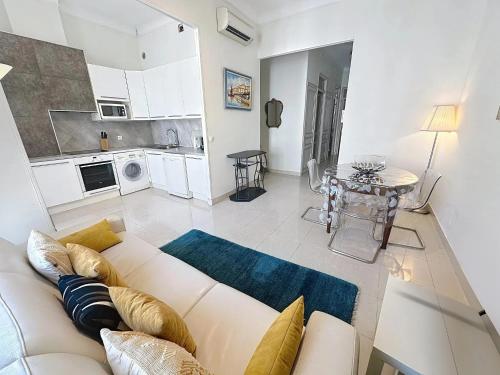 un salon avec un canapé blanc et une cuisine dans l'établissement 2 bedroom Forville. 8 mins from the Palais. 328, à Cannes