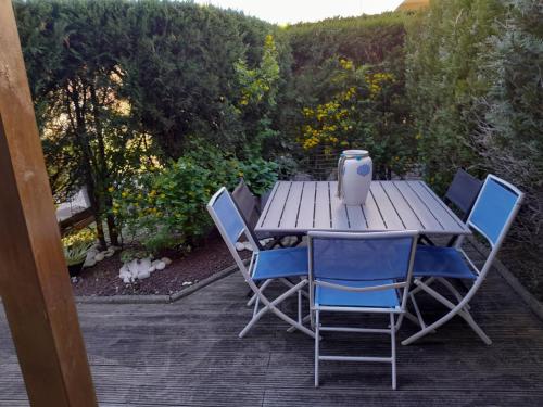 une table en bois avec des chaises et un vase. dans l'établissement Maison de la mer, à Vaux-sur-Mer