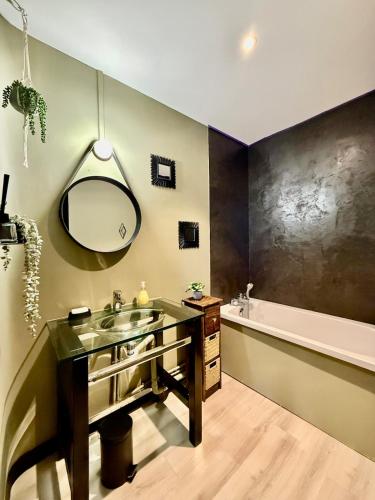 une salle de bain avec un lavabo, un miroir et une baignoire dans l'établissement Good Luck Rue de Strasbourg - DABNB, à Limoges
