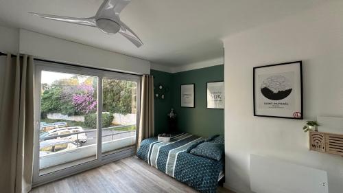 une chambre avec un lit et une porte coulissante en verre dans l'établissement Appartement rénové - Le Cosy à 150m de la mer, à Saint-Raphaël