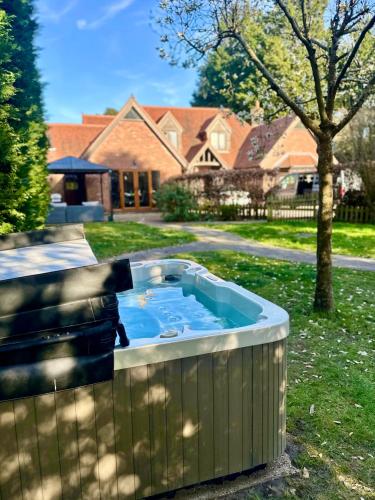 a hot tub in a yard in front of a house at Serene Retreat - Hot Tub - Pool Table - Close to New Forest and Bournemouth Beach - Sleeps 12 in Hurn