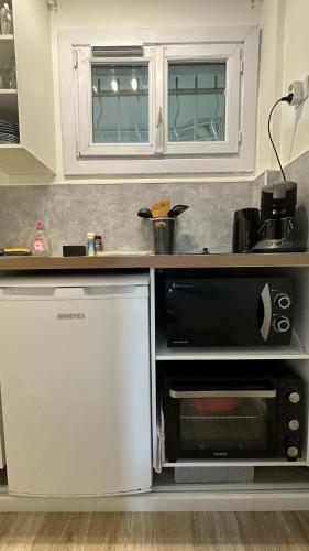 une cuisine avec une cuisinière et un micro-ondes dans l'établissement Appartement rénové - Le Cosy à 150m de la mer, à Saint-Raphaël