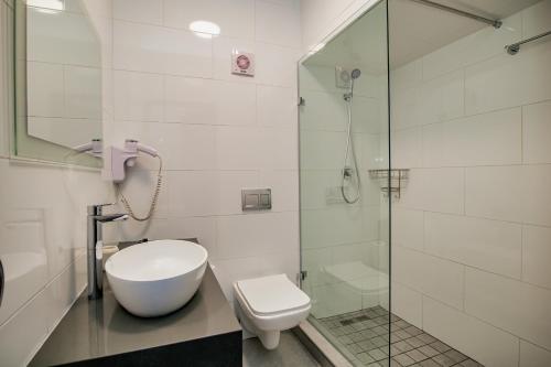 a bathroom with a toilet and a glass shower at 9 On Barrack in Cape Town