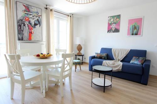 un salon avec une table et un canapé bleu dans l'établissement MAGE2 - Apartment 4ppl Serris Disneyland, à Serris
