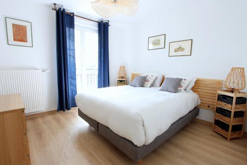 - une chambre avec un grand lit blanc et des rideaux bleus dans l'établissement MAGE2 - Apartment 4ppl Serris Disneyland, à Serris