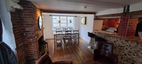 a living room with a table and a brick wall at Earsham Street House in Bungay