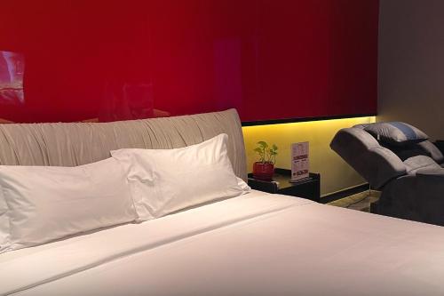 a bedroom with a white bed with a red wall at DongHu Resort Hotel in Sihanoukville