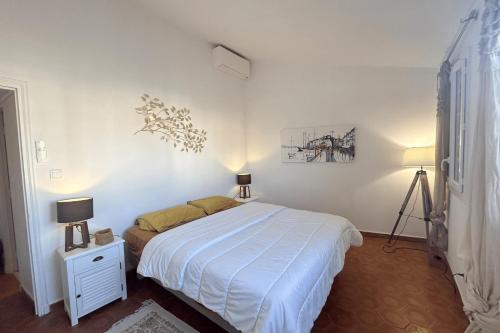 - une chambre blanche avec un lit et deux lampes dans l'établissement House with mooring - CenterClose to beach, à Grimaud