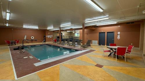 a large pool in a room with a table and chairs at Postcard Perfect in New Buffalo