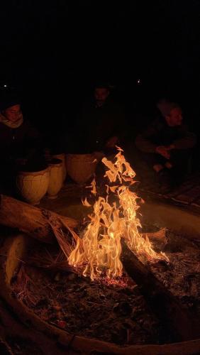 a fire is burning in a fire pit at night at Erg Chebbi Star Camp in Merzouga