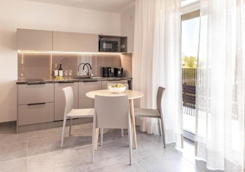 a kitchen with a table and chairs in a room at Lake-Apart Apartamenty Mielno in Mielno