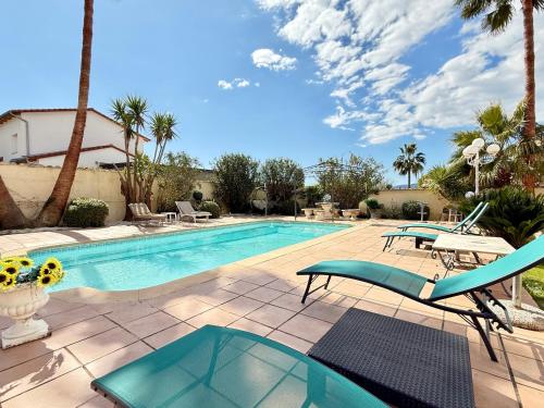 une piscine avec deux chaises et une table dans l'établissement Villa provençale avec piscine et sauna, à Mougins