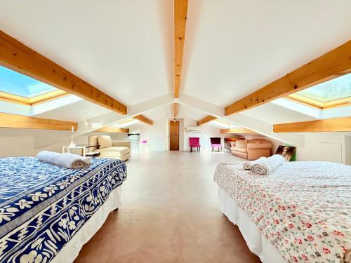 deux lits dans une grande pièce avec puits de lumière dans l'établissement Villa provençale avec piscine et sauna, à Mougins