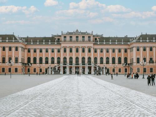a large building with people walking in front of it at Living Hotel an der Oper in Vienna