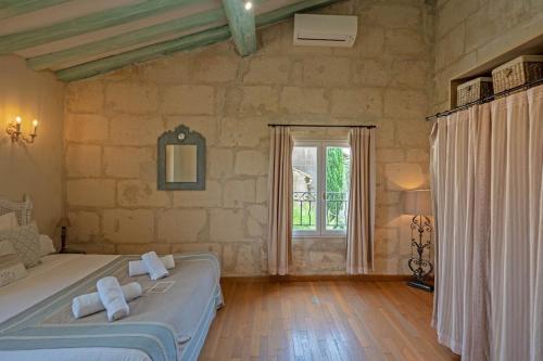 une chambre avec un lit et une grande fenêtre dans l'établissement Le Mas des Flammes, à Arles