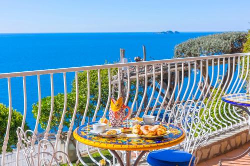 a table with a plate of food on a balcony at La Maliosa Positano in Positano