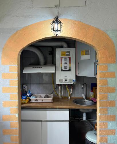 a kitchen with a brick wall and a counter with a sink at Chisinau Hostel in Chişinău