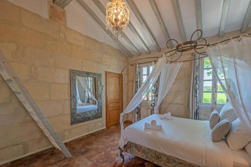 une chambre avec un lit et un lustre dans l'établissement Le Mas des Flammes, à Arles