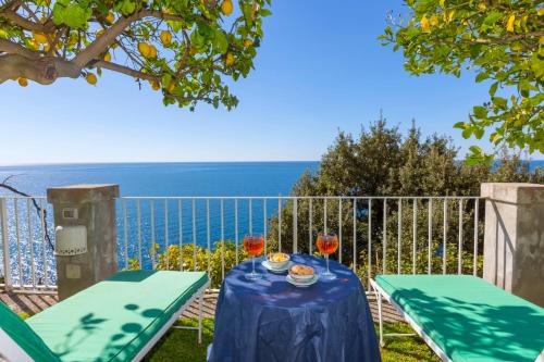 a table with two glasses of wine and a view of the ocean at La Maliosa Positano in Positano