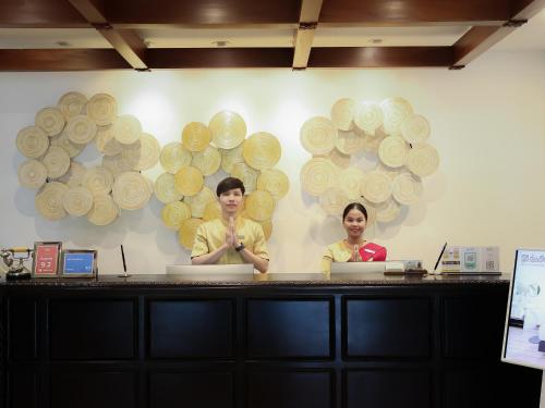two people standing behind a counter in a store at Jaya Suites Hotel in Phnom Penh