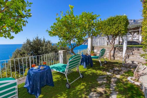 a table and chairs in the yard with a view of the ocean at La Maliosa Positano in Positano