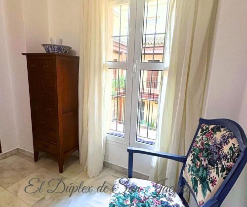 una stanza con finestra, sedia e cassettiera di El Dúplex de San Jacinto a Siviglia