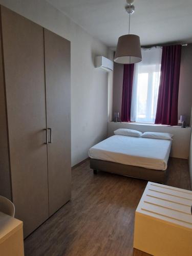 a bedroom with two beds and a cabinet in it at Hotel di Porta Romana in Milan