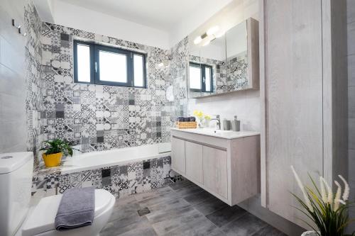 a bathroom with a tub and a sink and a toilet at Villa Narciso in Souda