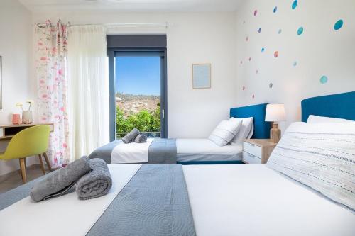 two beds in a hotel room with a window at Villa Narciso in Souda