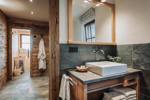 ein Badezimmer mit Waschbecken und Spiegel in der Unterkunft Alpzitt-Chalets in Burgberg