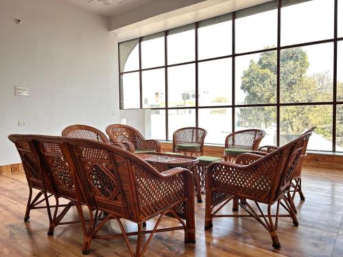 a room with a table and chairs and windows at HappyInn in Ayodhya