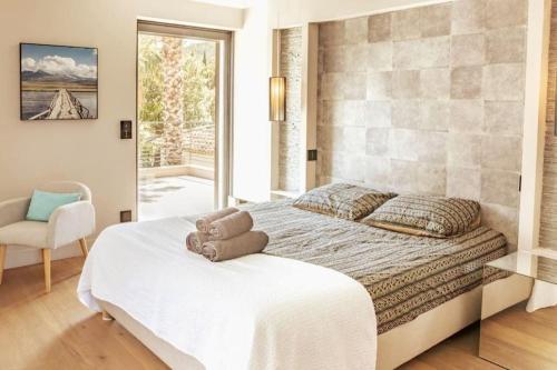une chambre avec un lit avec un ours en peluche dessus dans l'établissement Villa d'Exception Golfe de Saint-Tropez, au Plan-de-la-Tour