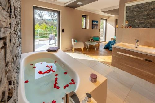 La salle de bains est pourvue d'une baignoire avec des pilules rouges. dans l'établissement Villa d'Exception Golfe de Saint-Tropez, au Plan-de-la-Tour