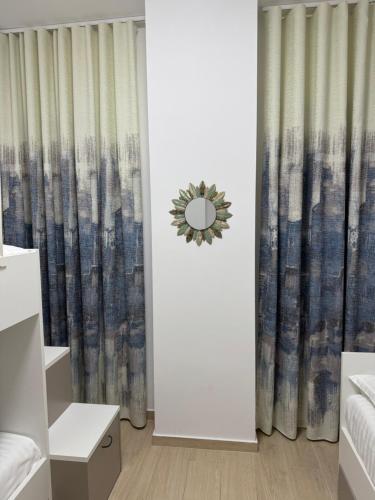 a bedroom with a curtain and a mirror at Luris apartament Himare in Himare