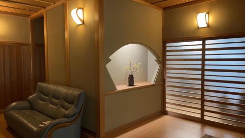 a living room with a chair and a window at suzume in Imabari