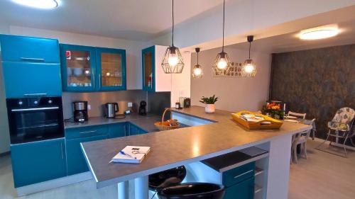 a kitchen with blue cabinets and a large island at O naturel in Buzancy