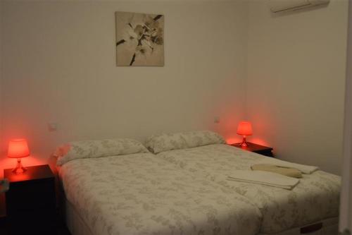 a bedroom with a bed and two lamps on two tables at Casa Lucero in Rojales
