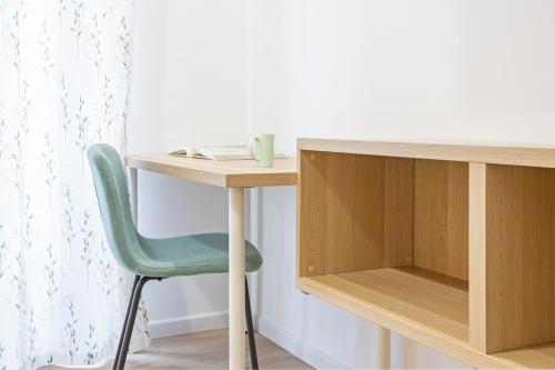 a desk with a green chair next to a table at Maison Celeste B&B 2 e 4 in Rome