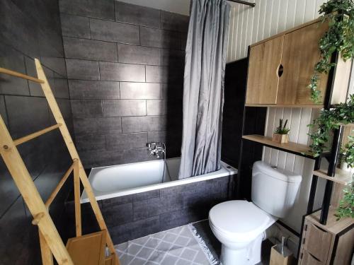 La salle de bains est pourvue de toilettes blanches et d'une baignoire. dans l'établissement Ashley, à Concarneau