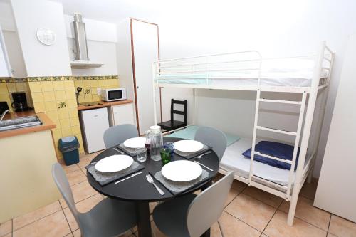 - une salle à manger avec une table et des lits superposés dans l'établissement Grand studio 4 50m de la plage pour 4, à Argelès-sur-Mer