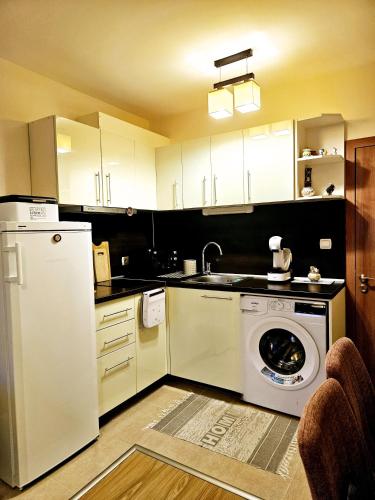 a kitchen with a white refrigerator and a washing machine at САМИ апартамент к-с "Нестинарка" СВ9 in Tsarevo